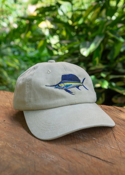 Back view of Ben’s Originals vintage beige sailfish cap with blue embroidered logo and adjustable strap, photographed outdoors on a wooden table.